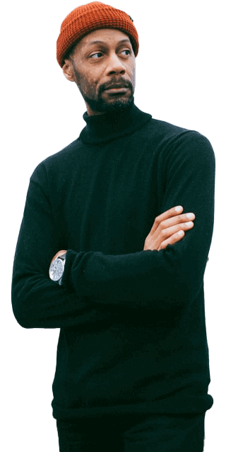 A man wearing a black turtleneck sweater and orange beanie.
